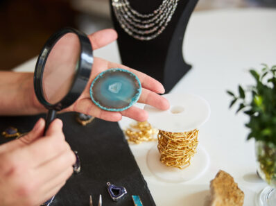 Female master examining a gemstone slice for flaws